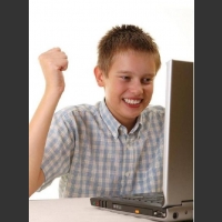 Dzieciak cieszy się przed komputerem